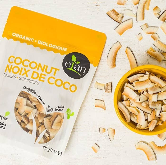 A bag of coconut smiles next to a bowl of coconut smiles