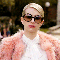 Emma Roberts in a pink faux fur coat and over-sized sunglasses crying