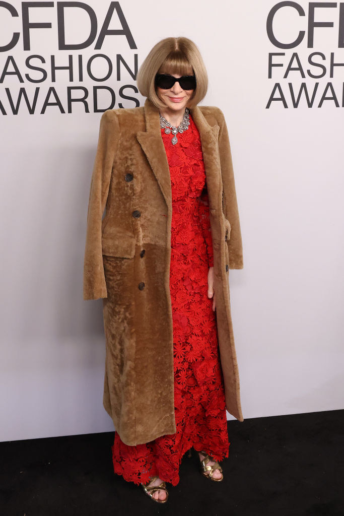 anna wearing a long lace dress under a fur coat and sunglasses