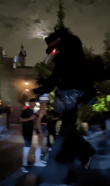 GIF of a 12 foot tall crow like monster walking by