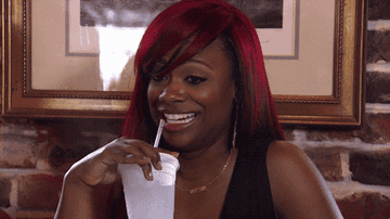 Kandi Buress making a face and sipping her drink