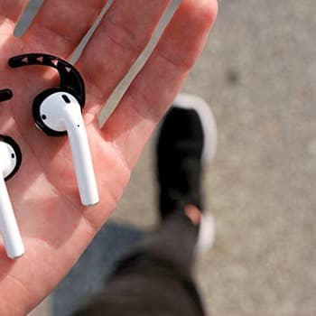 close up of airpods with small black hooks on them