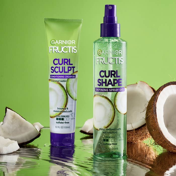 A bottle of cream-gel and defining spray gel with sliced coconuts