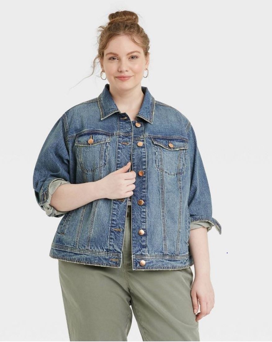 model wearing medium wash jean jacket with brass buttons