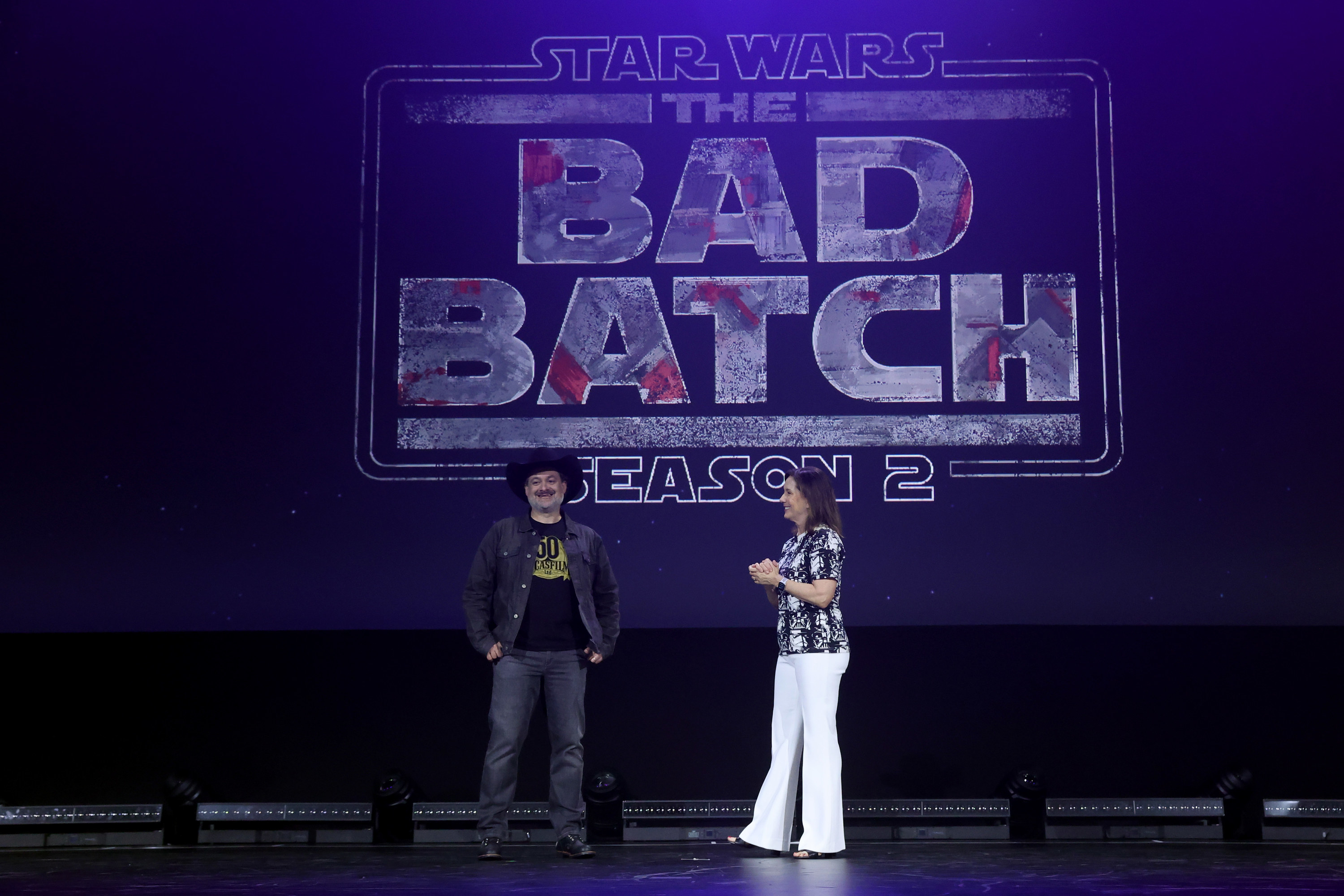 Dave Filoni and Kathleen Kennedy stand in front of a Bad Batch Season 2 logo