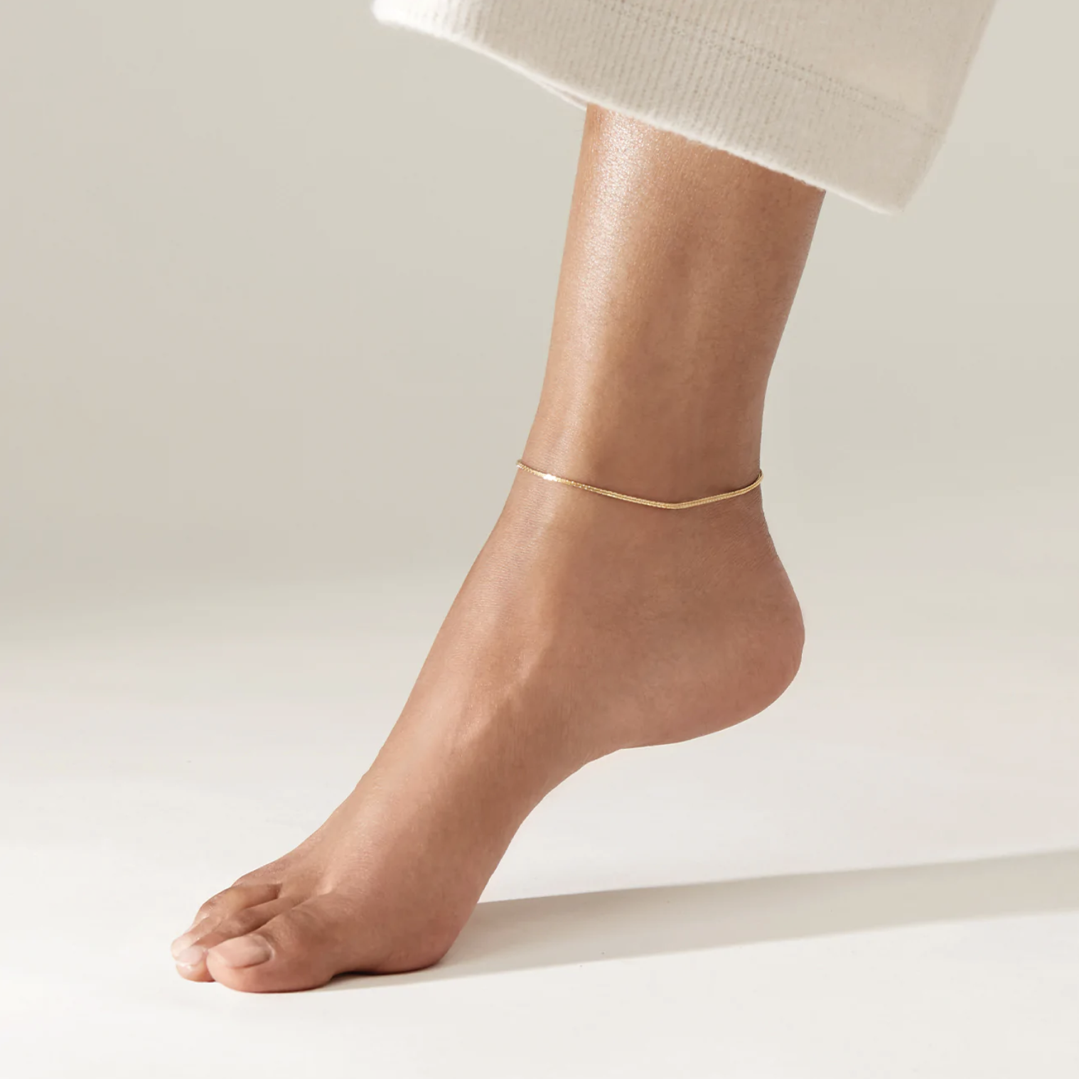 A person wearing cropped pants and the anklet