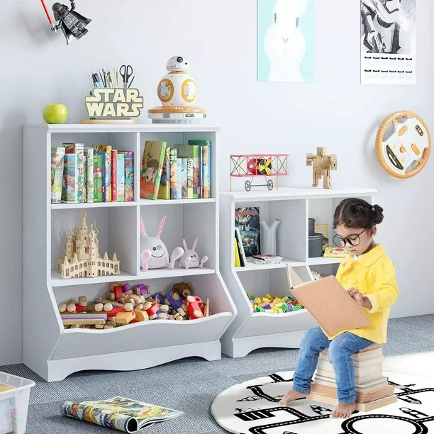 Child reading in front of toy storage
