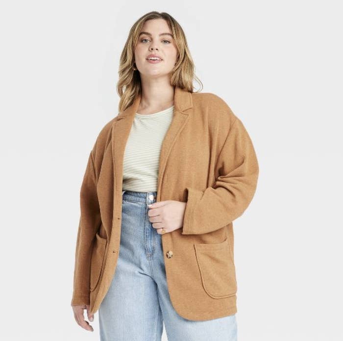The model is wearing the tan color with jeans a striped top