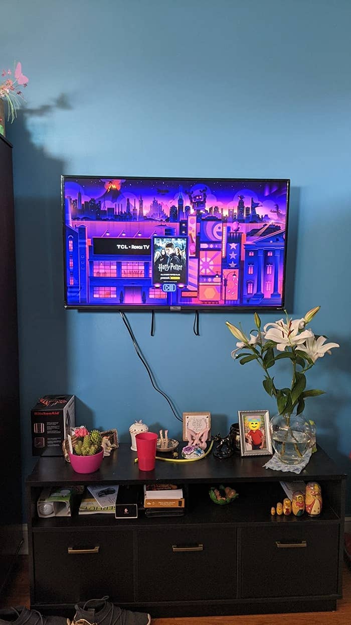 Reviewer&#x27;s tv mounted to wall about entertainment center