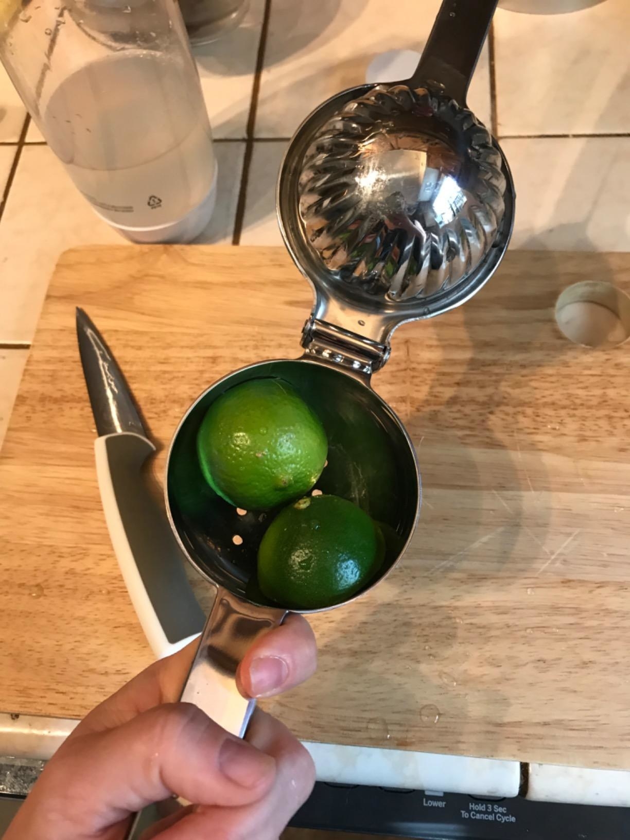 Reviewer holding the squeezer with two lime halves in it