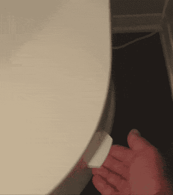 Gif of reviewer using the tab to lift their toilet seat