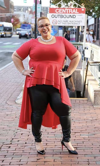 reviewer wearing faux leather leggings with red top and black heels
