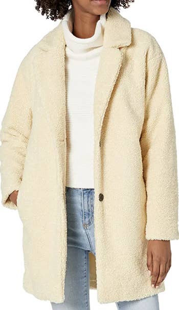 model wearing coat in butter yellow color with jeans