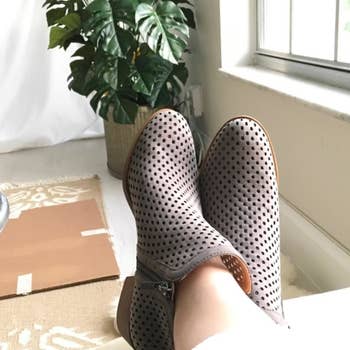 a reviewer wearing the boots in gray featuring perforated detailing