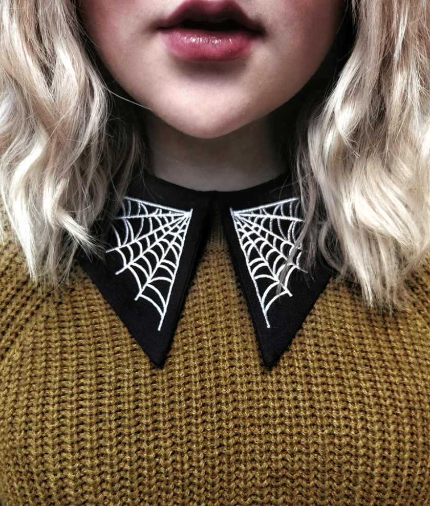 Model wearing the black removable collar with white spider webs on each lapel