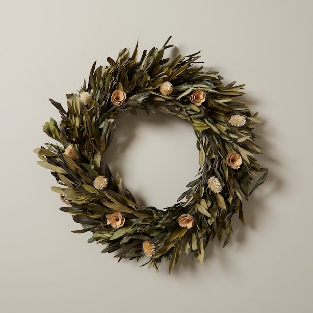 an olive leaf wreath hung on a wall