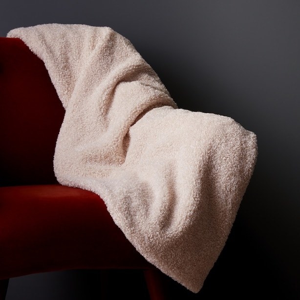 a double-sided blanket with shaggy high pile faux fur on one side and fleece on the other