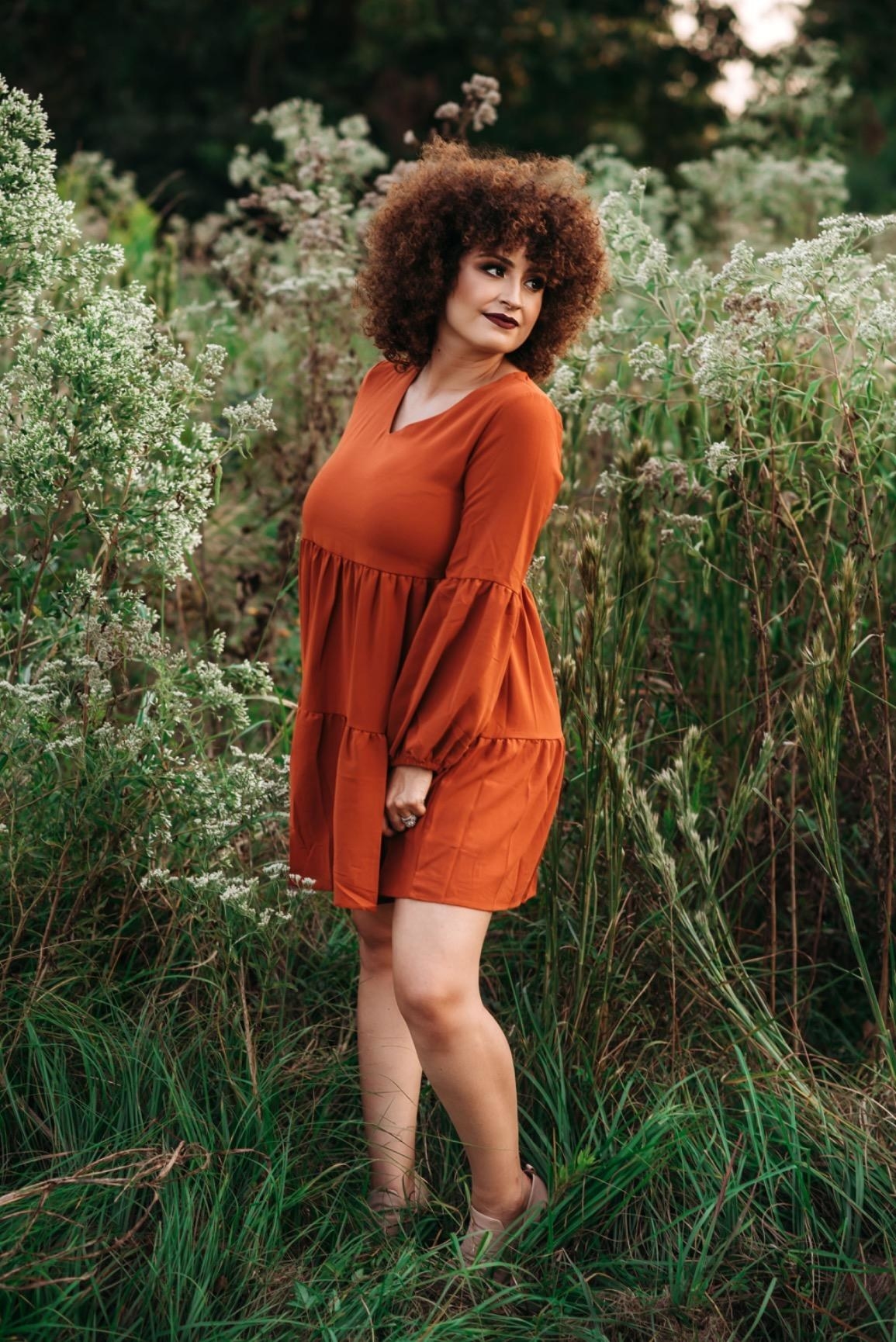 Reviewer wearing the orange dress and posing in a field