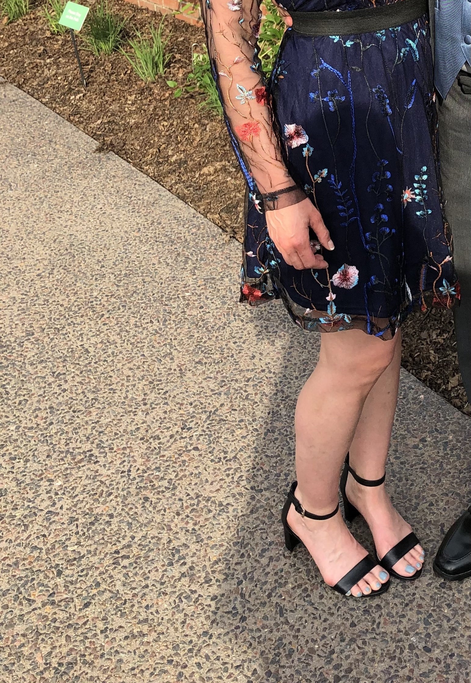 Reviewer wearing the black chunky heel sandals with a dress