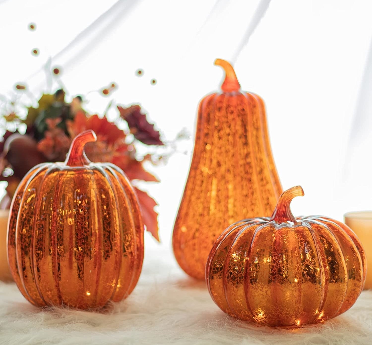 a trio of pumpkin-shaped mercury glass lights