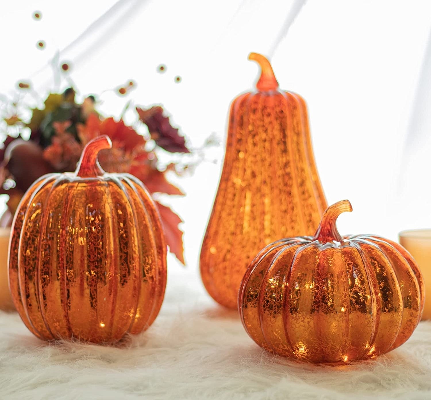 a trio of pumpkin-shaped mercury glass lights