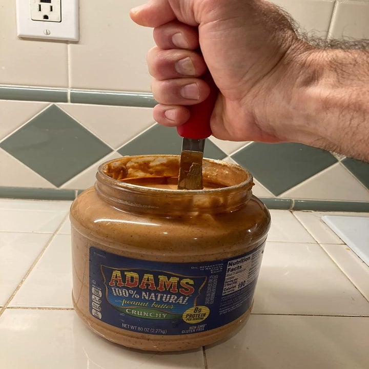 reviewer image of the knife in a jar of natural peanut butter