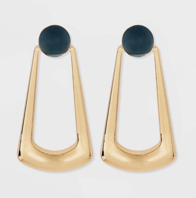 The gold drop earrings have a rounded bottom and deep teal circles at the top