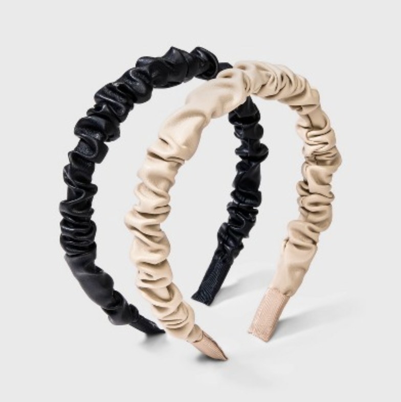There's a cream and black option displayed with ruched faux leather open headbands