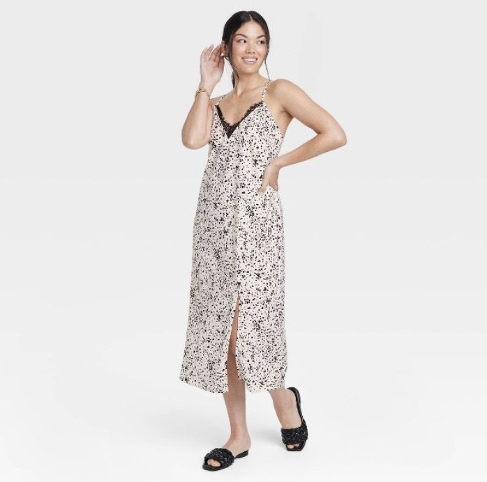 The model wears the long cami dress in the black and white pattern