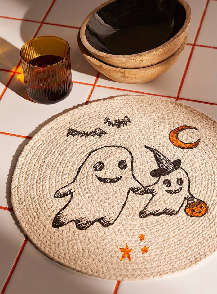 a circular cotton placemat with a graphic of two cute ghosts on the front