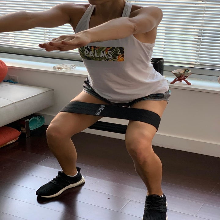 reviewer using the black resistance band while in a squat