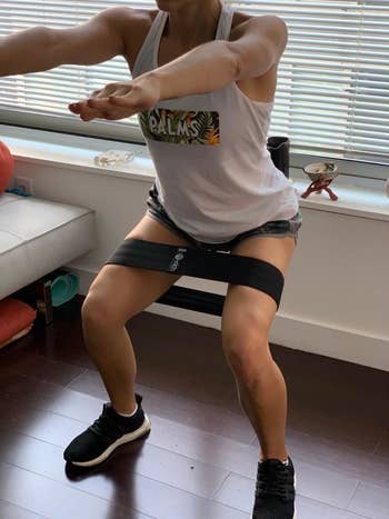 reviewer using the black resistance band while in a squat