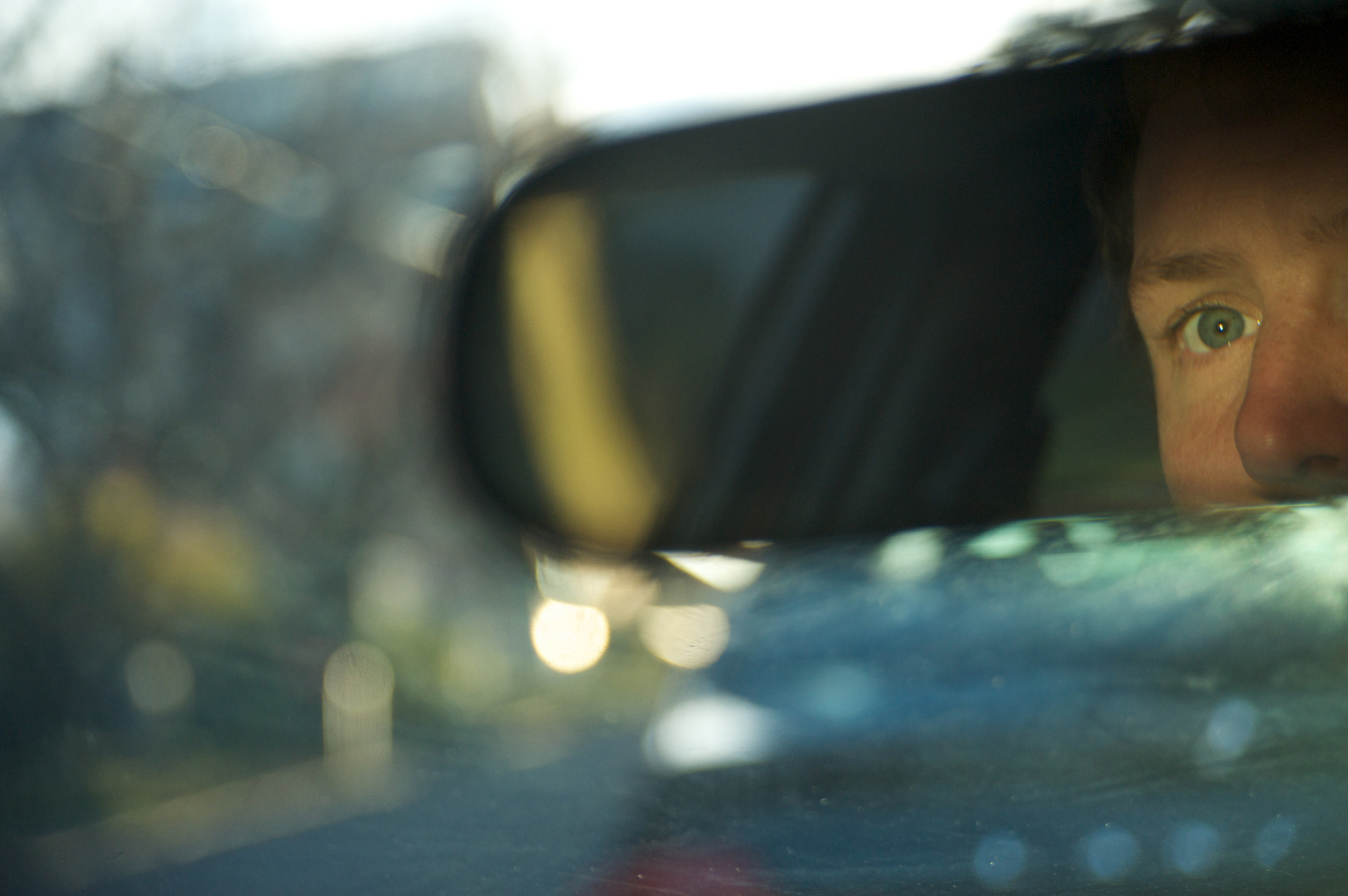 person looking in rear view mirror