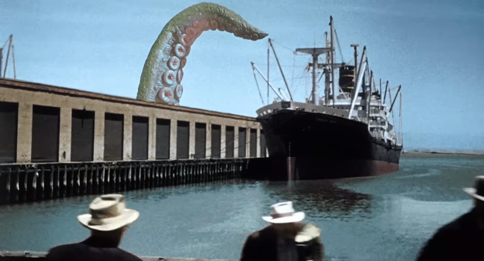 A massive octopus tentacle looms over a ship