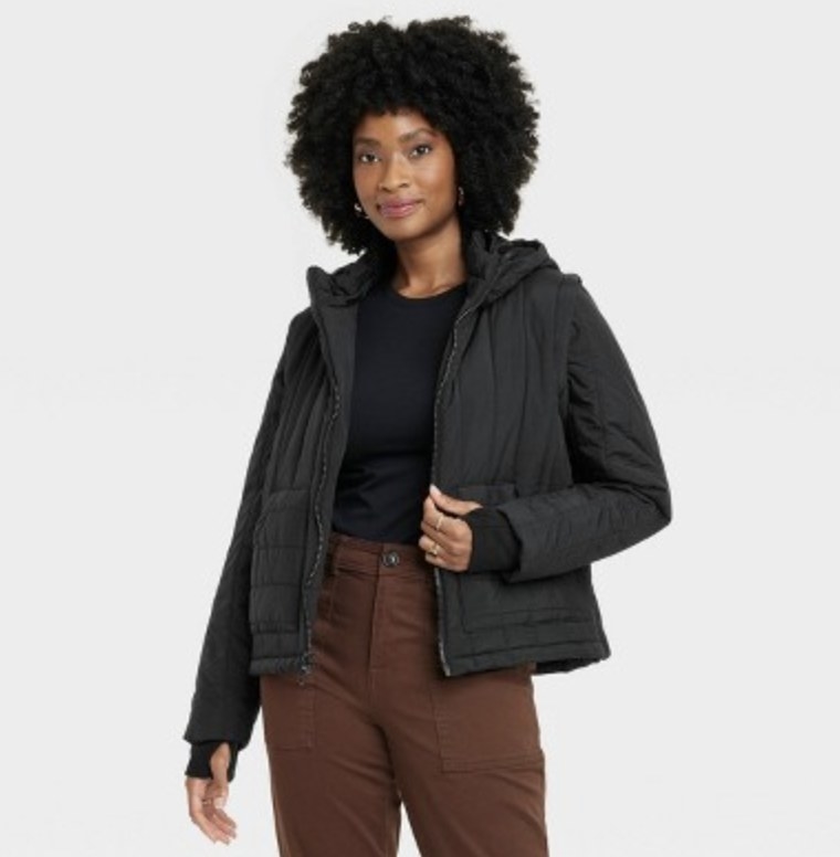 The model wears the black puffer with brown pants