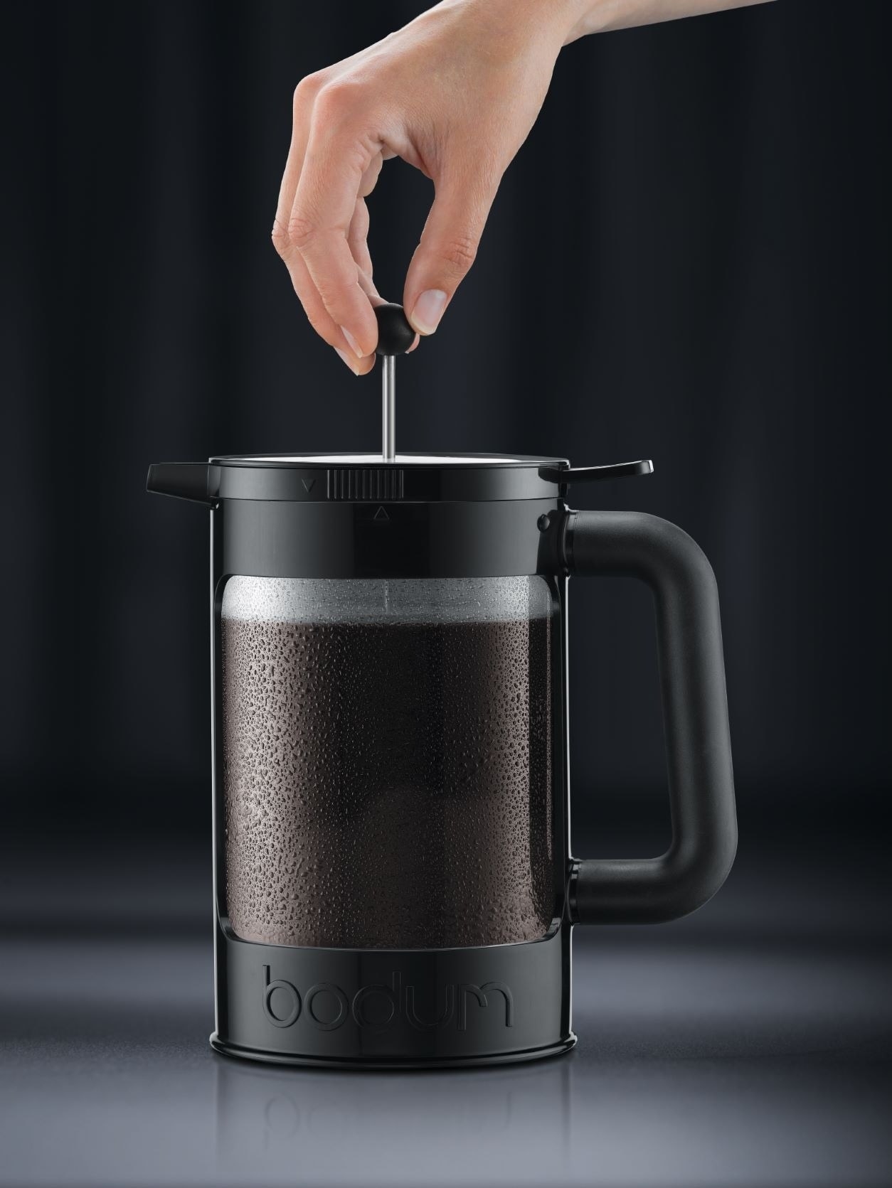 a hand using the coffee maker