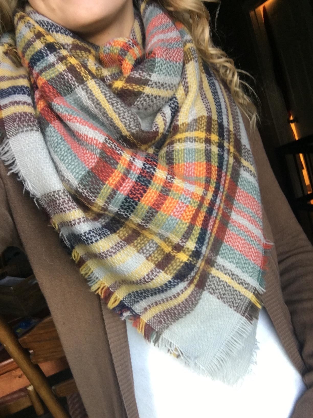 Reviewer wearing plaid scarf, white shirt and brown cardigan