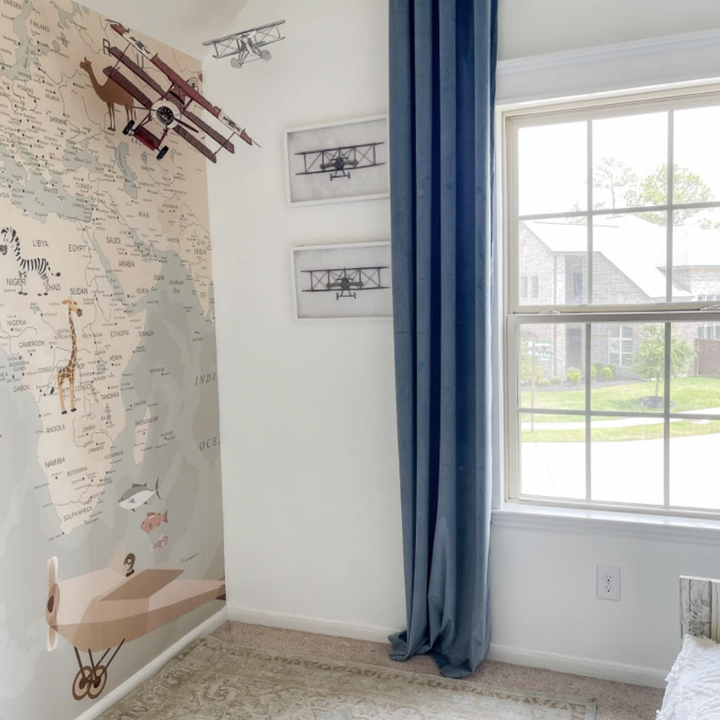 a reviewer with the velvet curtains hanging in a child's playroom