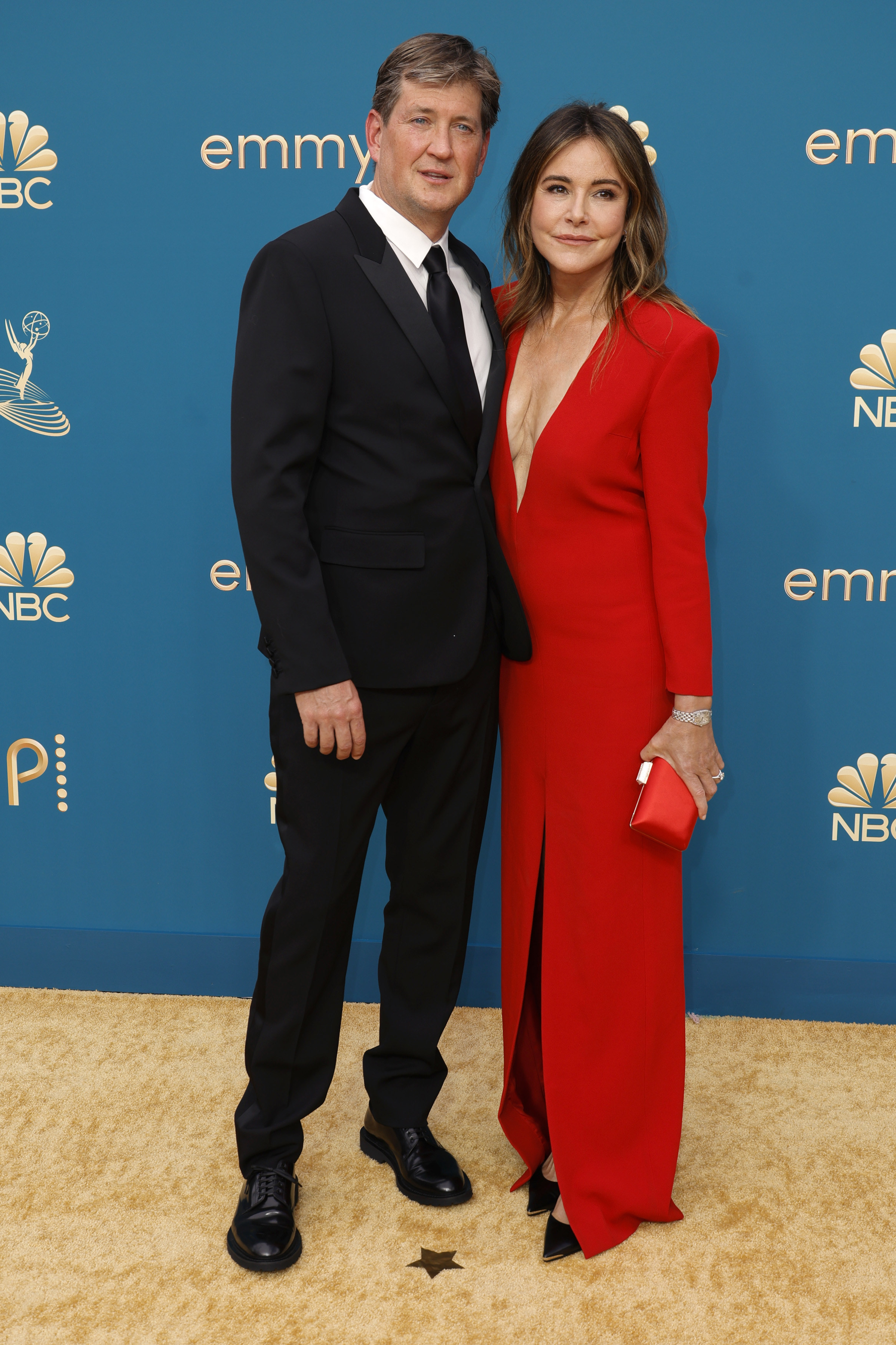 Bill Lawrence in a suit and Christa Miller in a red gown