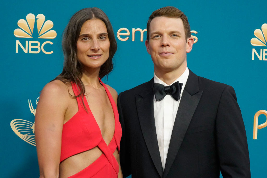 Lauren DeLeo in a cutout orange dress and Jake Lacy in a tux