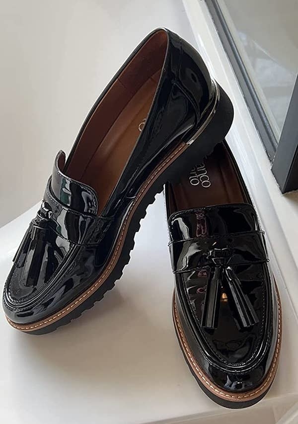 A reviewer photo of a pair of the the black patent loafers with tassels on the toe