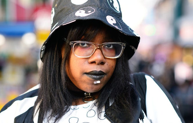 close up of a woman with black lipstick and lip piercing