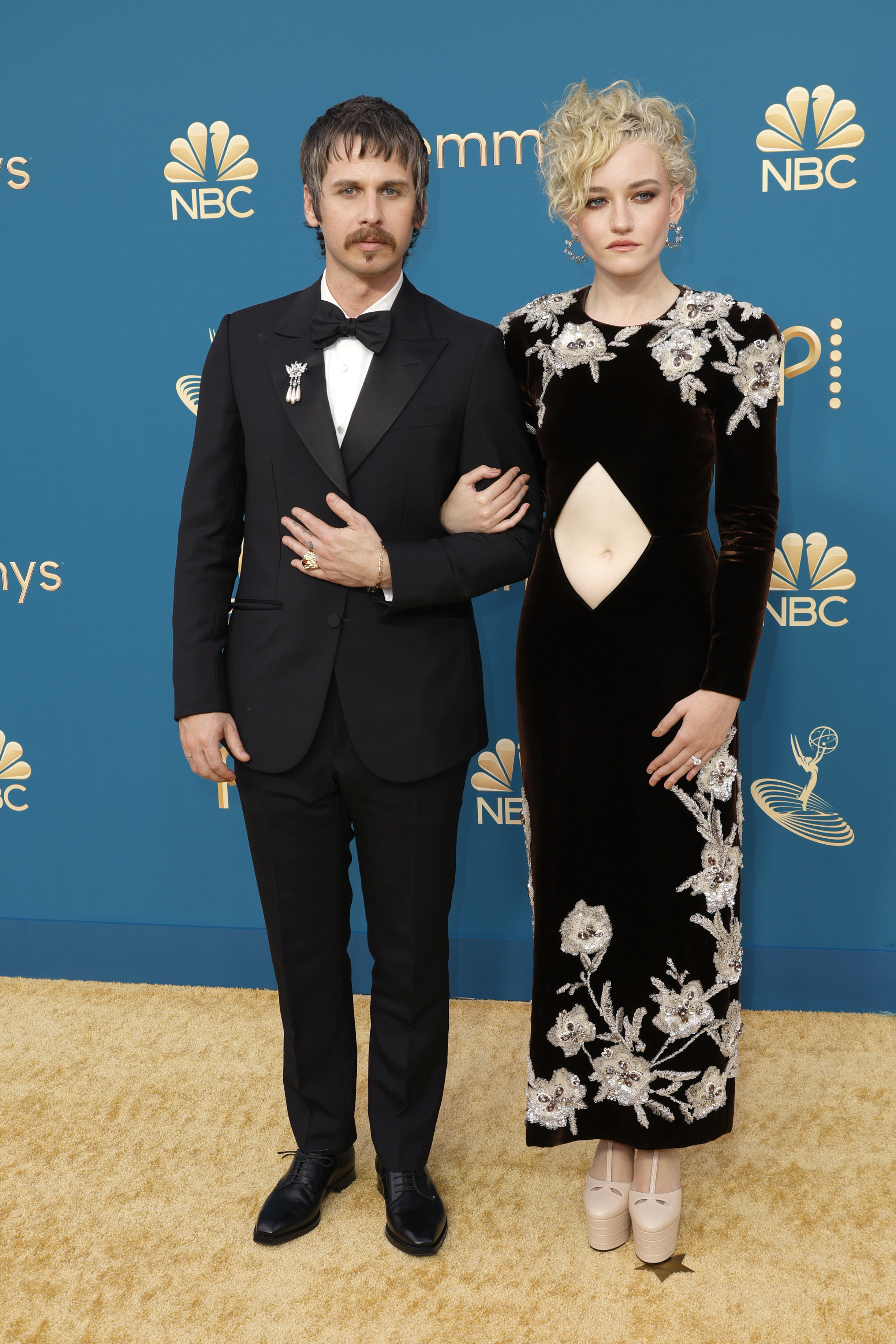 Julia Garner in a floral black cutout gown and Mark Foster in a black tux