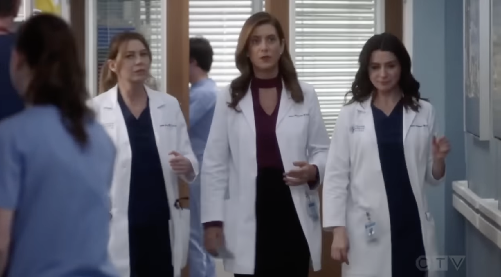 Meredith Grey, Addison Shepherd and Amelia Shepherd are walking down a hospital hallway, all wearing lab coats