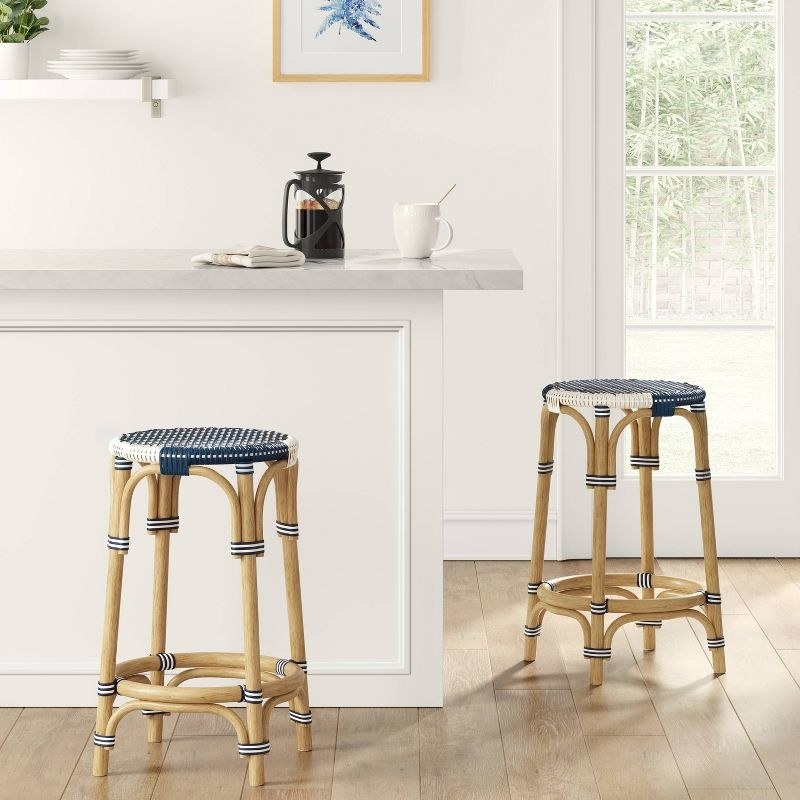 Two stools in the navy color next to a countertop