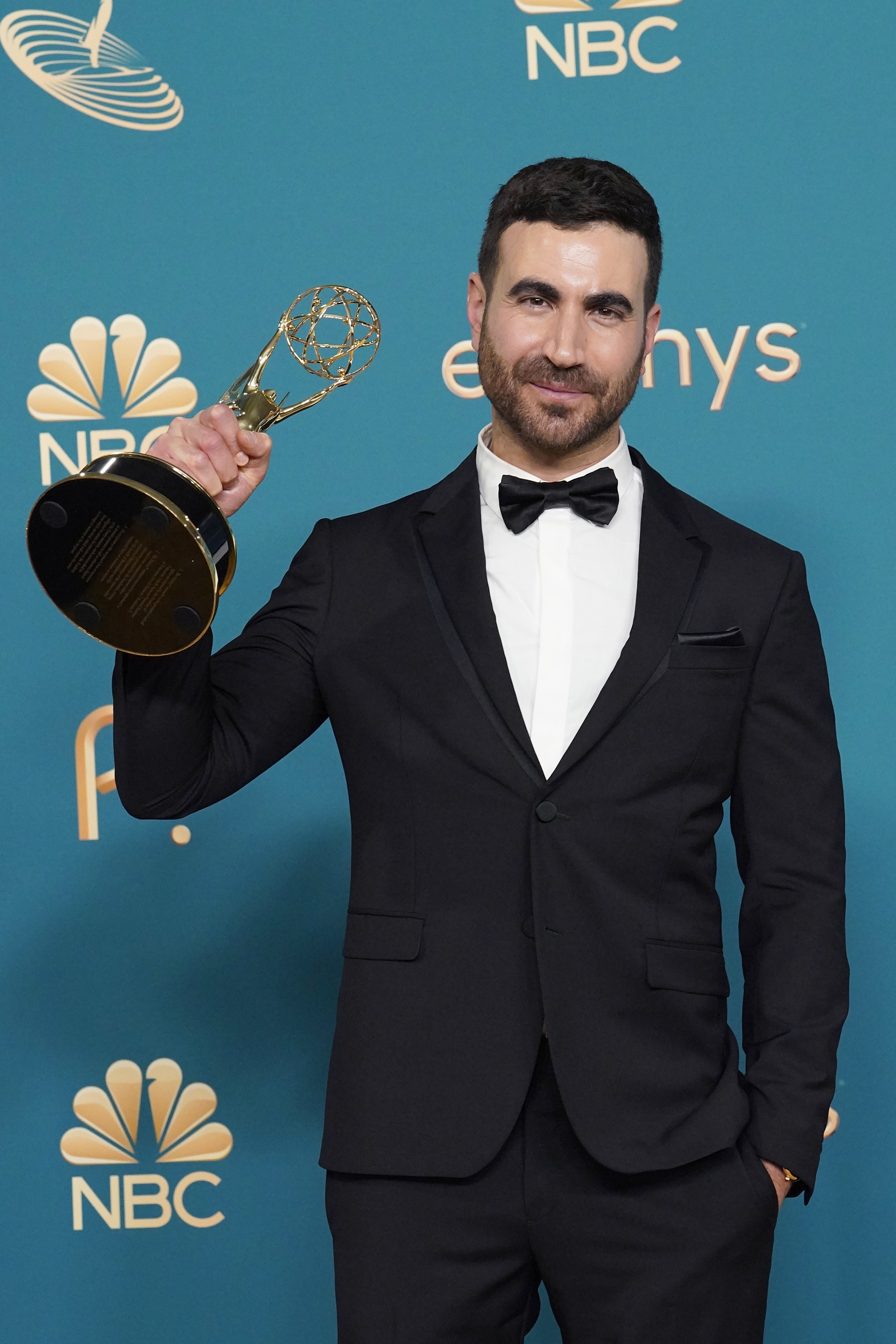 Brett Goldstein smiling and holding up his Emmy