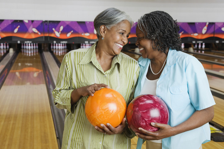 Two women holding bowling balls