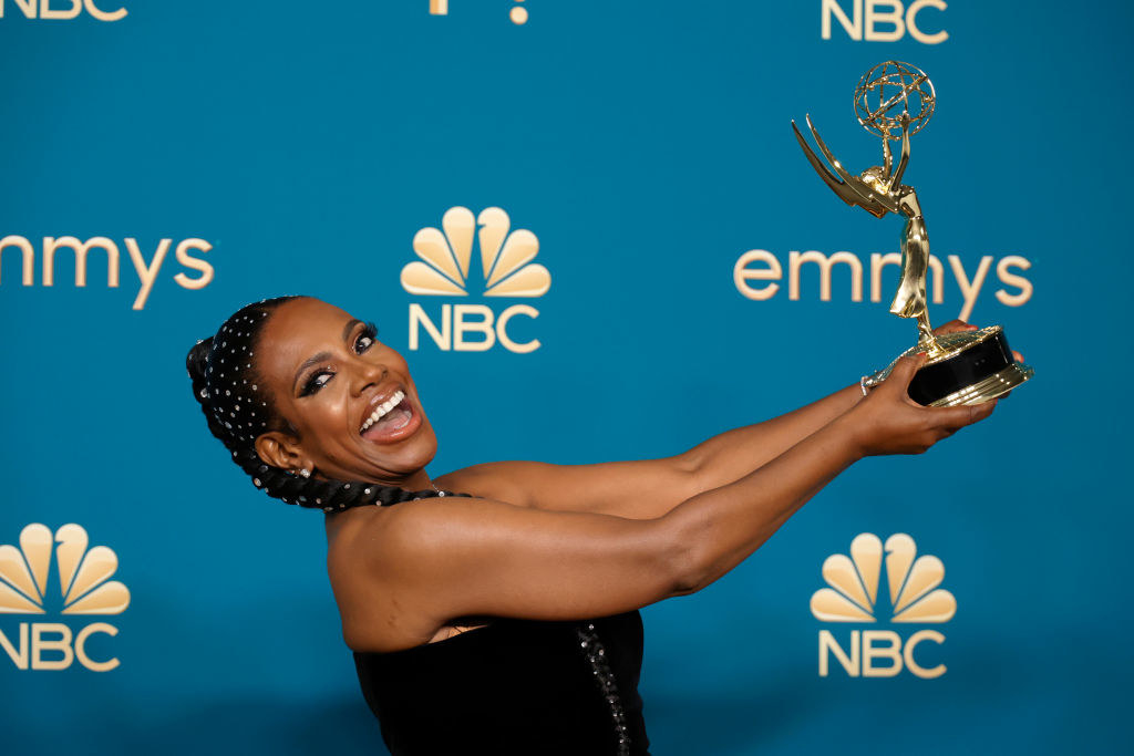 Sheryl excitedly holding her Emmy