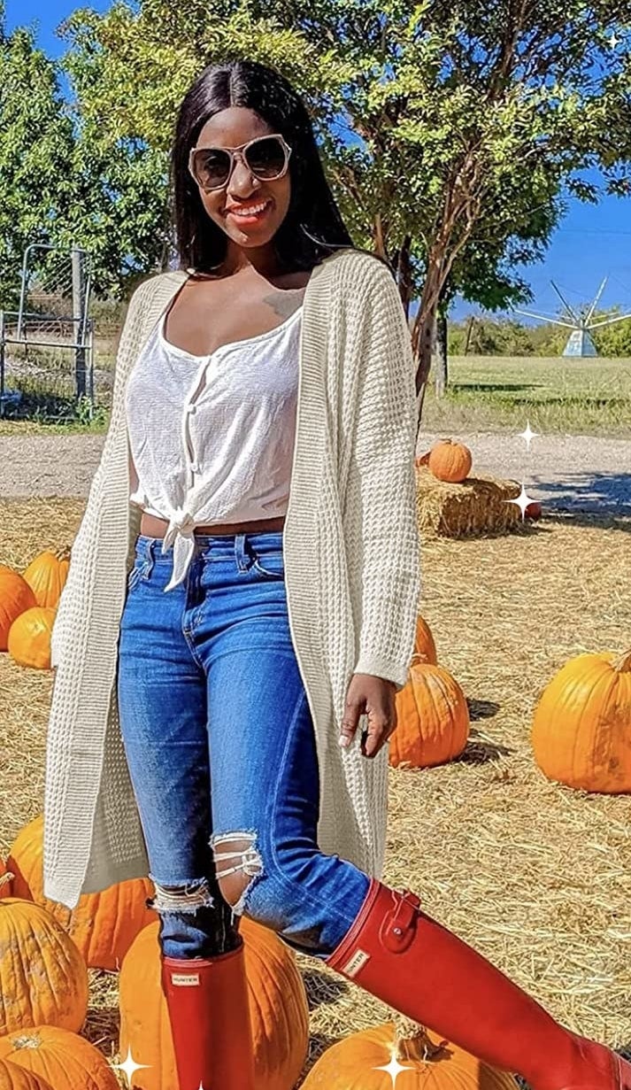 a person wearing the cardigan while at a pumpkin patch
