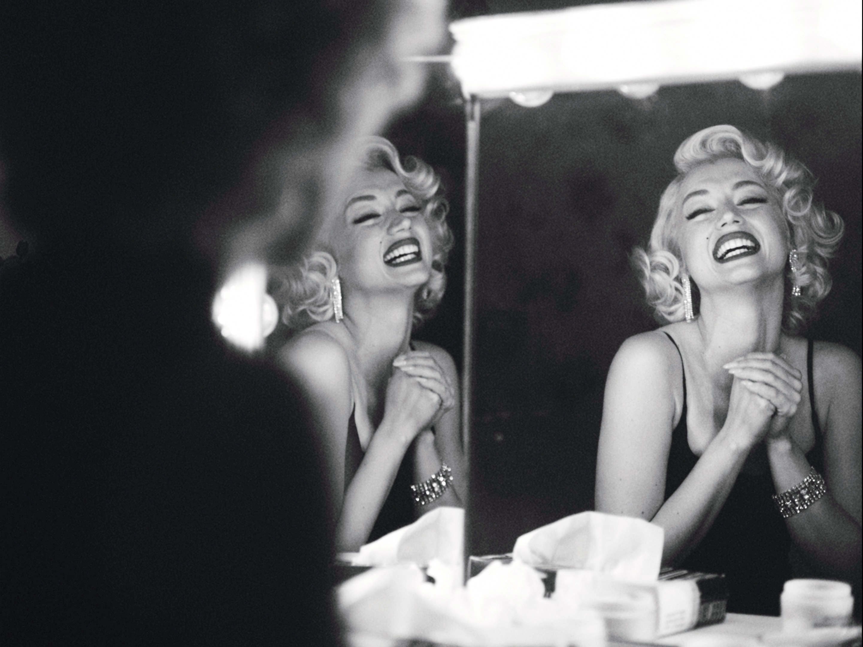 A woman laughs at her own reflection
